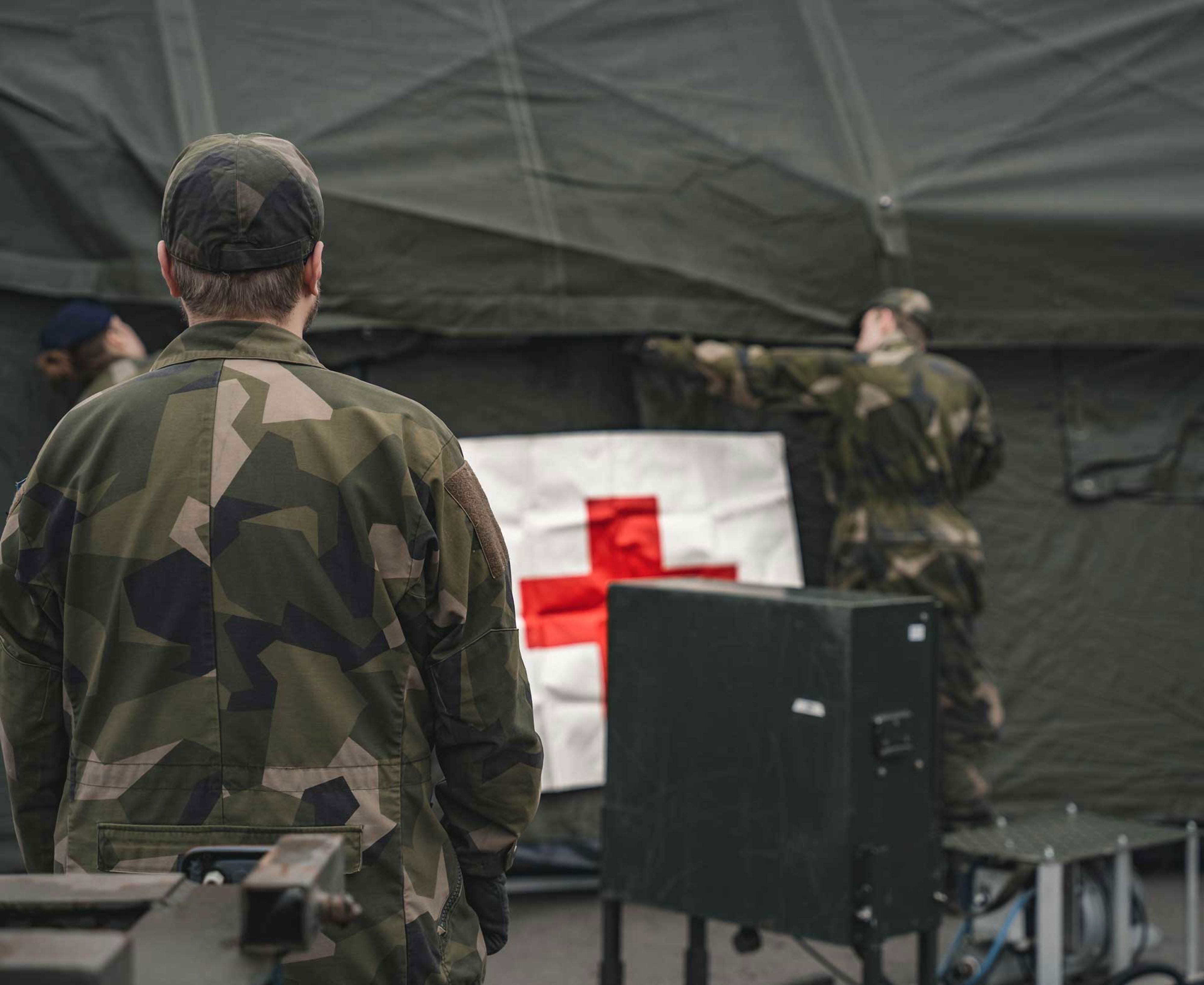 Ett par soldater sätter upp ett sjukvårdstält.