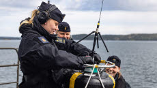 Tre sjömän sjösätter en sonarboj