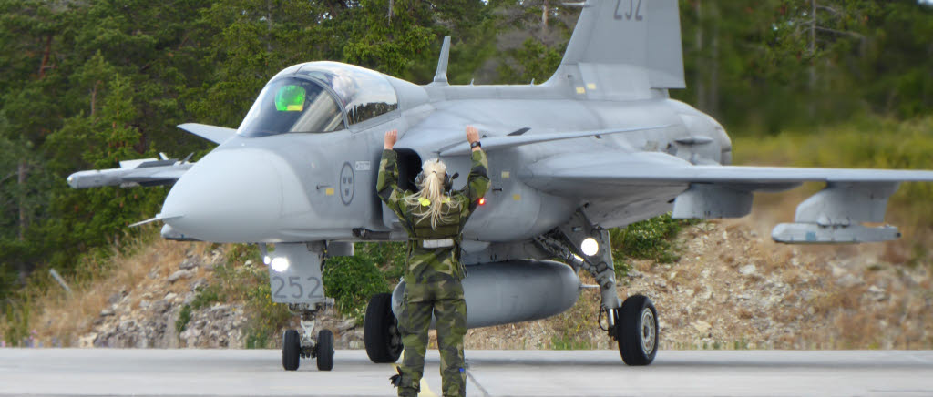 Flygmekaniker vinkar in ett flygplan på F 17:s sidobas på Gotland