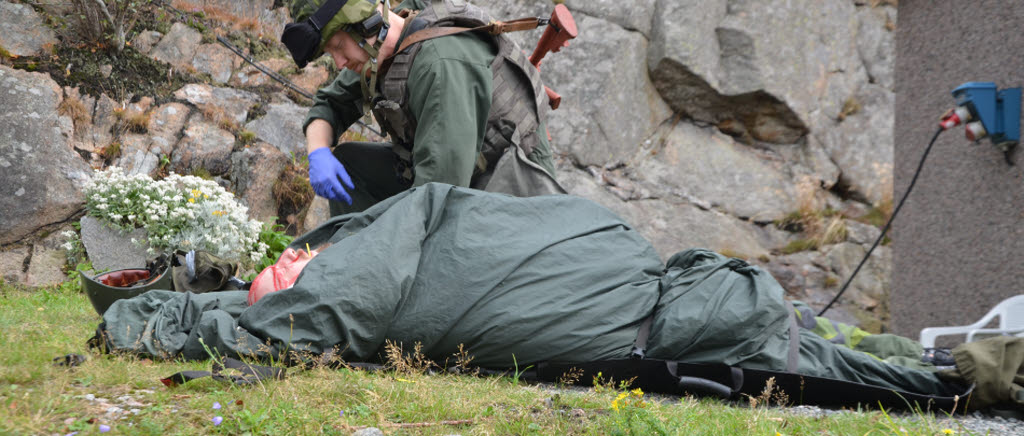 två soldater med splitterskador. Deras bil har kört på en hemmagjord bomb s k IED. Här är sjukvårdspersonal på plats som snabbt ser om skadorna och ger smärtlindring.