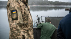 Ukrainsk soldat bredvid svensk stridsbåt