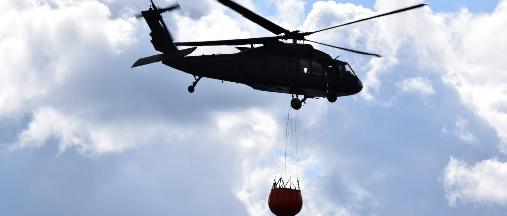 Helikopter 16 med fylld tunna. Under inflygning kan det gå i drygt 80 knop för att sedan gå ner till nästan stillastående då vattnet släpps. Brandbekämpning.