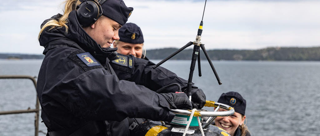 Tre sjömän sjösätter en sonarboj