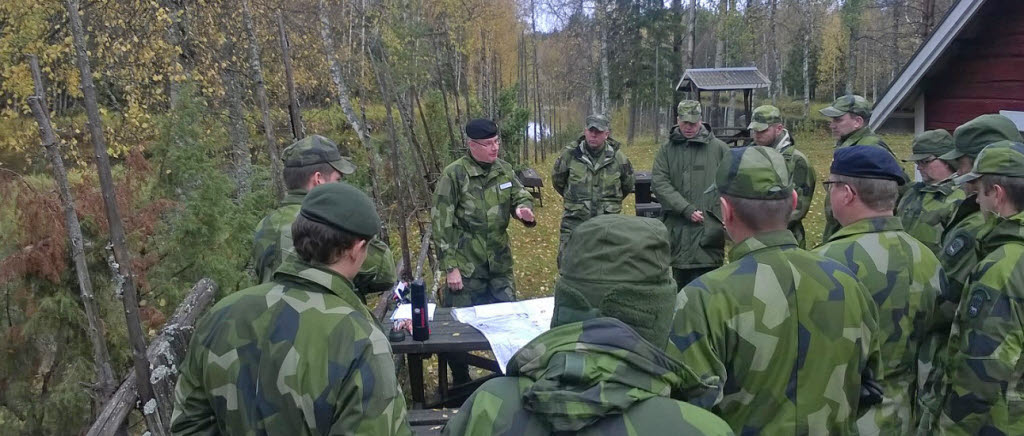 Brigadchefen Lars Karlsson under diskussion avseende brigadledning med del av fältövningsdeltagarna invid Sangis älv.

