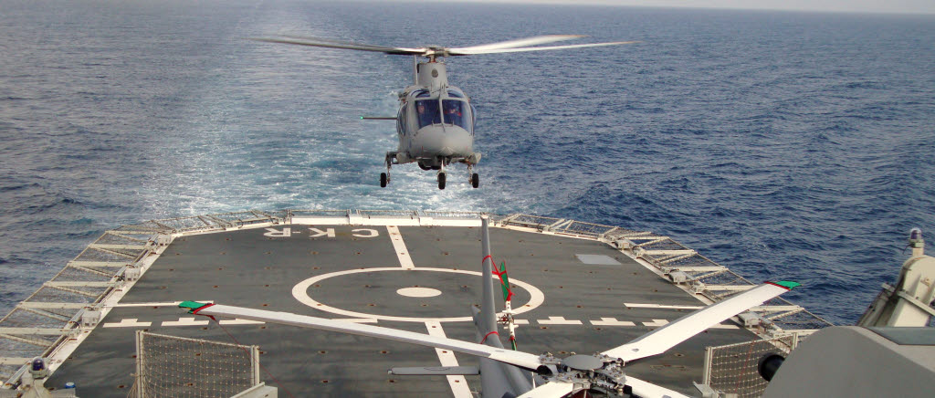 Liten flygplats på stort hav, en Helikopter 15 går in för landning. 