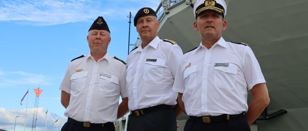Chefer från Försvarsmakten framför ett fartyg. 