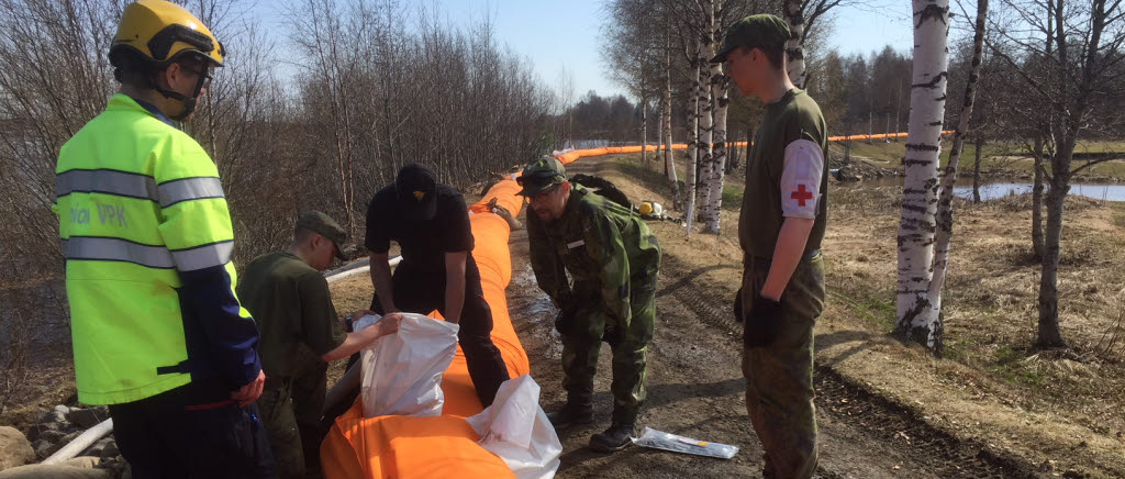 Myndigheterna på båda sidor om gränsen mellan Sverige och Finland samarbetar för att hindra att de stora vattenflöden som snösmältningen skapat orsakar skador. Här fyller svenska hemvärnssoldater tillsammans med finska värnpliktiga och finska frivilliga brandmän den 1,5 km långa barriären med vatten.