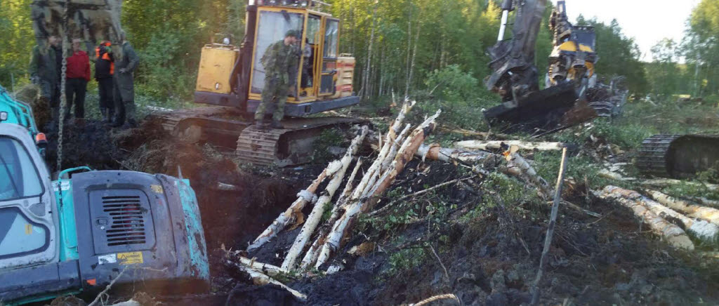 Bärgningsarbeten av en bandgrävare som sjunkit ned i en myr. Smedsbyn, Boden, 25 juni, 2014.