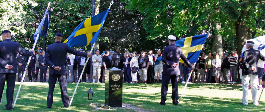 Veterandagen firas i Halmstad 29 maj 2014.
Fanvakten vid minnesstenen och där bakom syns veteraner och övriga deltagare uppställda.