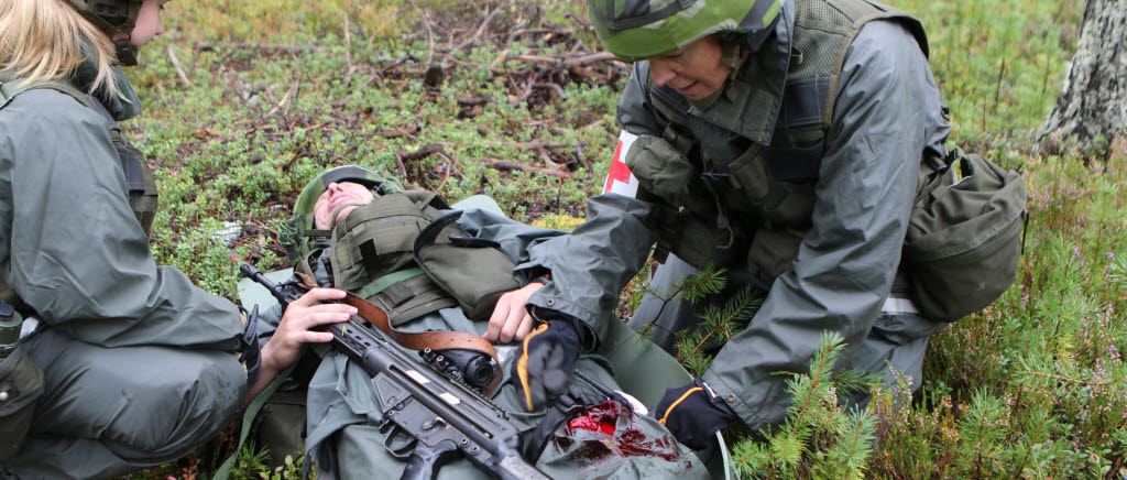 Sjukvårdsmoment med omhändertagande av skadad i strid,  Therese Bergström sjukvårdare och Jenny, Andersson, kompanissjuksköterska på Kalix hemvärnsinsatskompani tar hand om Hans Turtola, skademarkör under övningsmomentet.