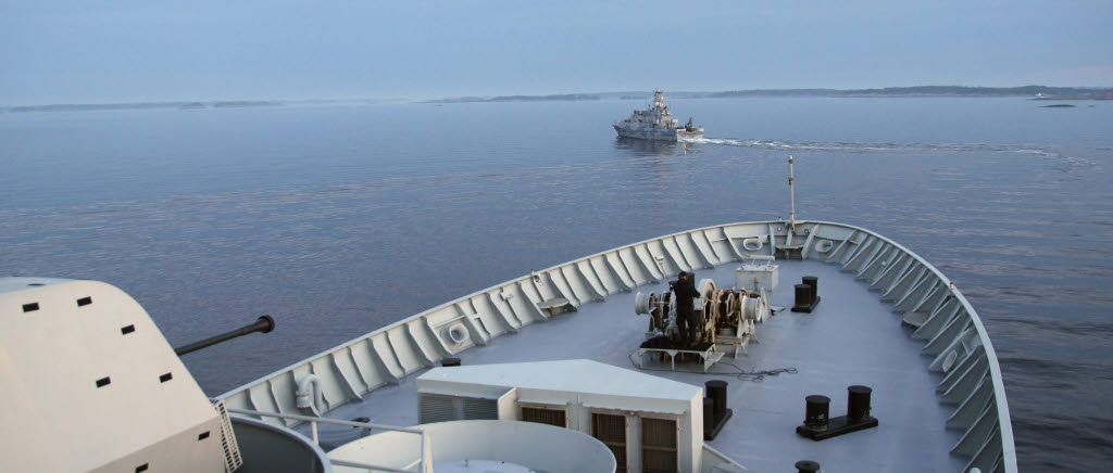 HMS Carlskrona följer efter minröjningsfartyget, med ett par hundra meters mellanrum.