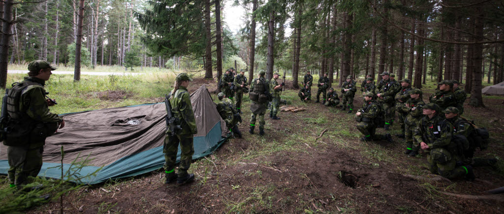 Rekryter lyssnar på sitt befäl ute i skogen.