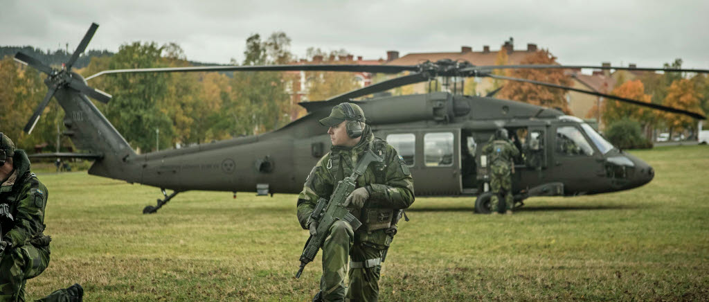 Soldater från 13.säkbat i Östersund med Helikopter 16 i bakgrunden. 