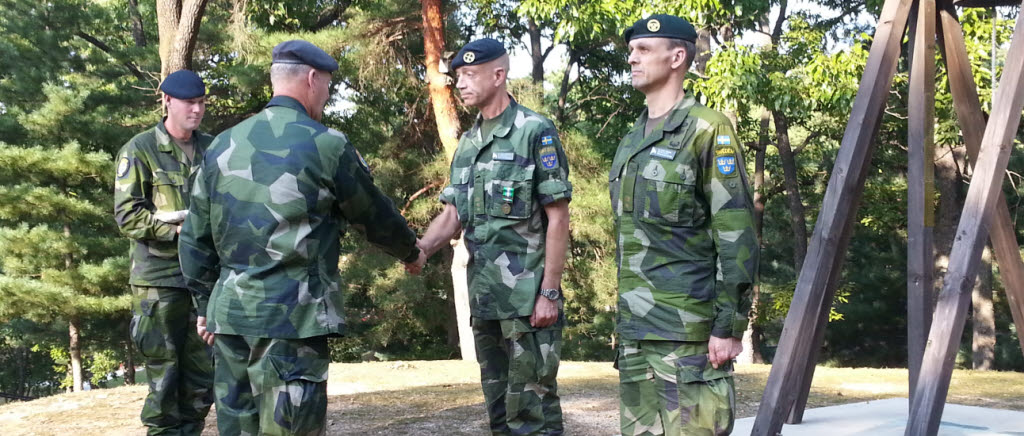 Generalmajor Berndt Grundevik medaljerar överstelöjtnant Patrick Karlsson och major Peter Forsberg.