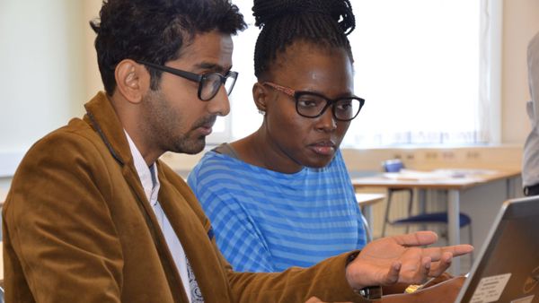Two people are looking at a screen together.