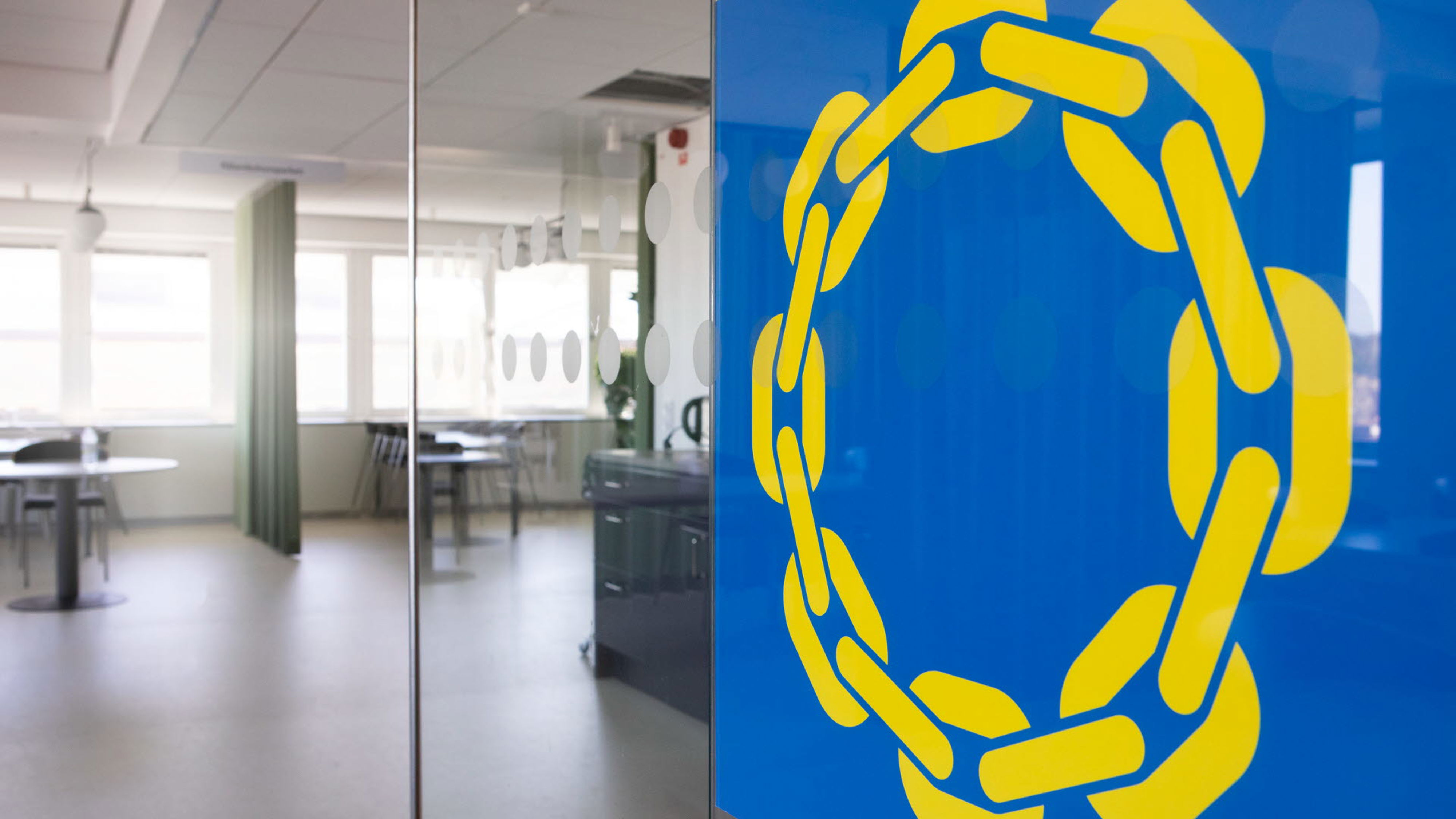 Banner med blå bakgrund med en gul cirkel på ett kontor