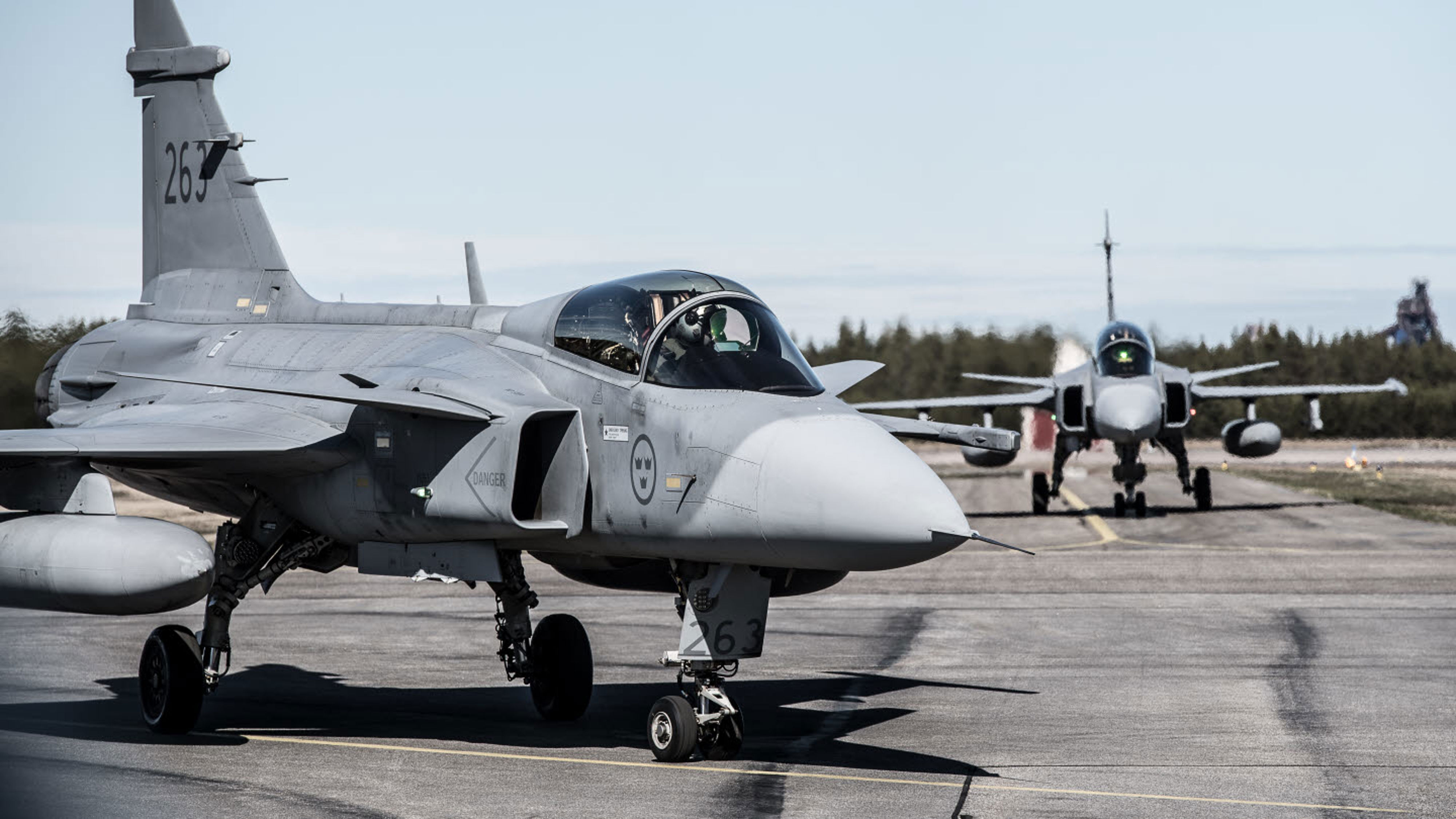 två JAS 39 Gripen flygplan å startbanan